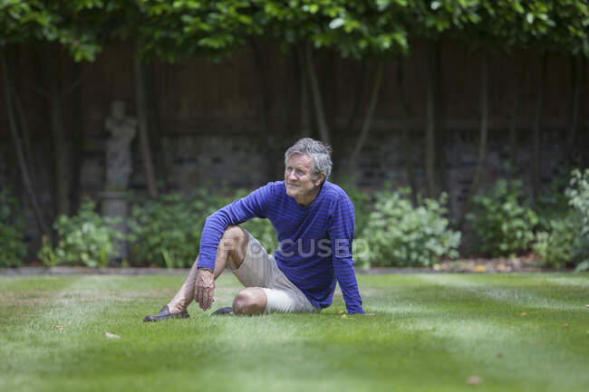 Hombre mayor sentado en el jardín - foto de stock