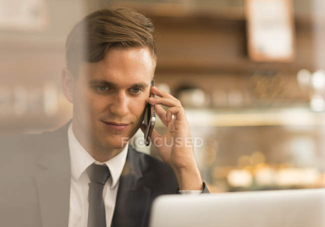 Empresario trabajando en el ordenador portátil en la cafetería - foto de stock