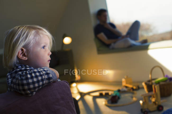 Ragazzo con i capelli biondi guardando lontano con il padre sullo sfondo — Foto stock
