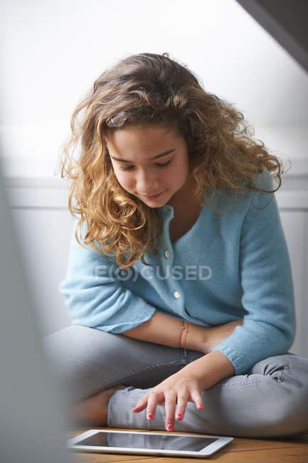 Kleines Mädchen mit lockigem Haar mit digitalem Tablet — Stockfoto