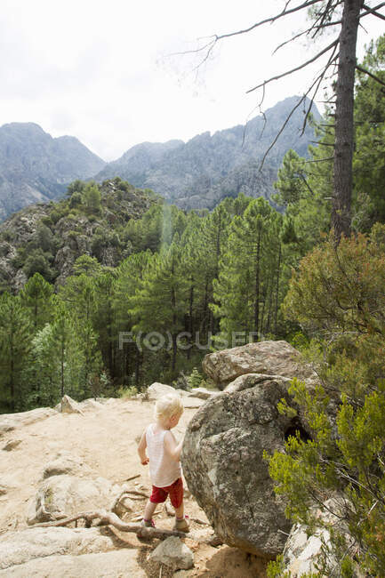 Female toddler exploring mountain rocks, Calvi, Corsica, France — Stock Photo