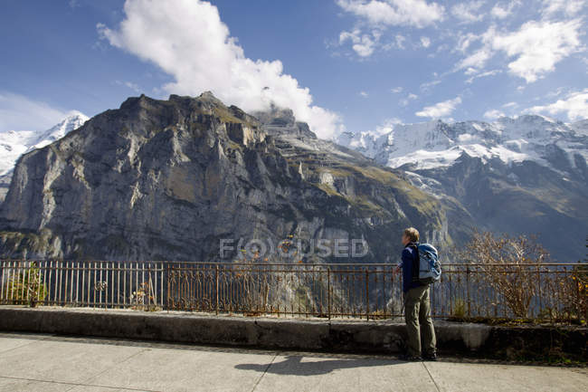 Caminante masculino mirando hacia el norte del Monte Eiger, Murren, Grindelwald, Suiza - foto de stock