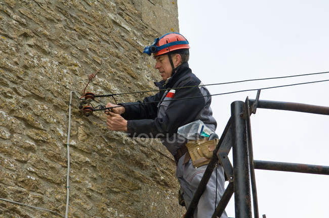 Электрик-мужчина на платформе для ремонта электроснабжения дома — стоковое фото