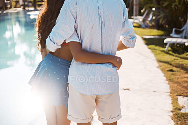 Rear mid section view of young couple embracing at poolside, Koh Samui, Thailand — Stock Photo