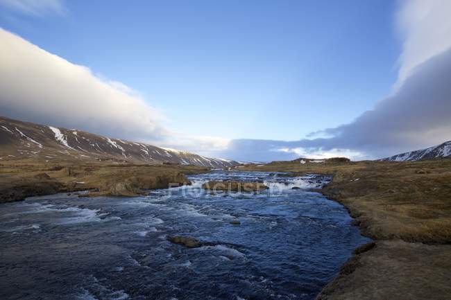Rio Brynjudalsa e colinas sob céu azul, Islândia — Fotografia de Stock