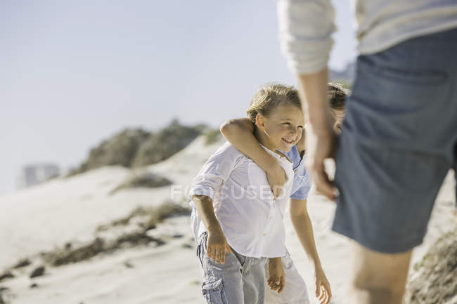 Отец и сыновья на пляже — стоковое фото