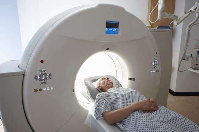 Mature man going into CT scanner indoors — Stock Photo