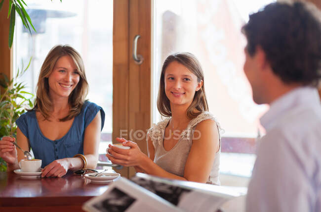 Grupo de amigos charlando en la cafetería bar - foto de stock