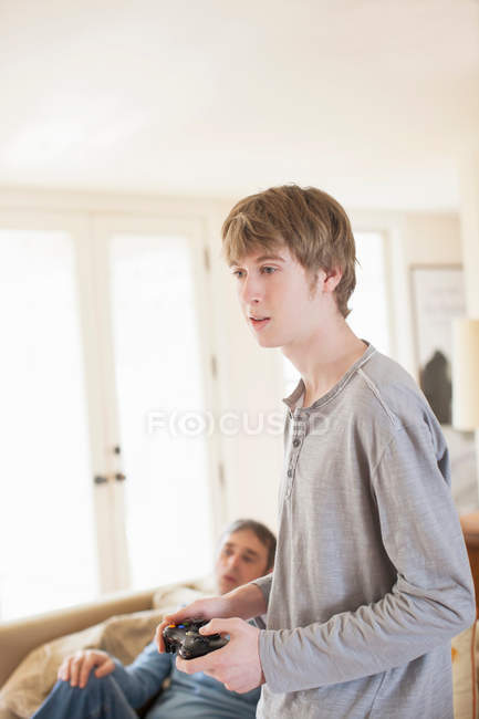 Father and son playing video game in living room — Stock Photo