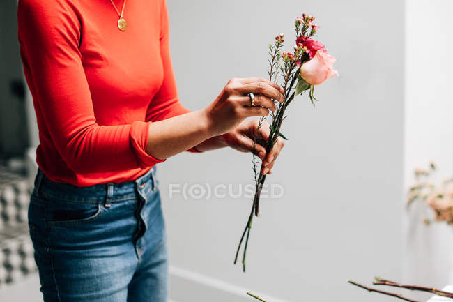 Обрезанное изображение женщины-флориста, держащей срезанные цветы в цветочном магазине — стоковое фото