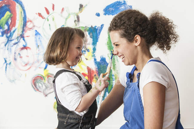 Mère et fille jouant avec la peinture — Photo de stock