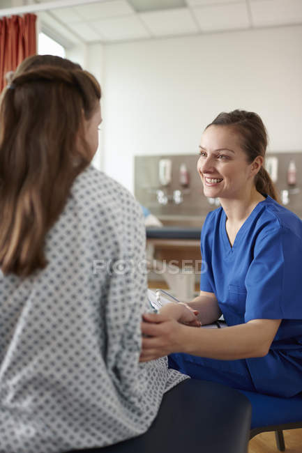 Nurse talking to elementary age female patient — Stock Photo