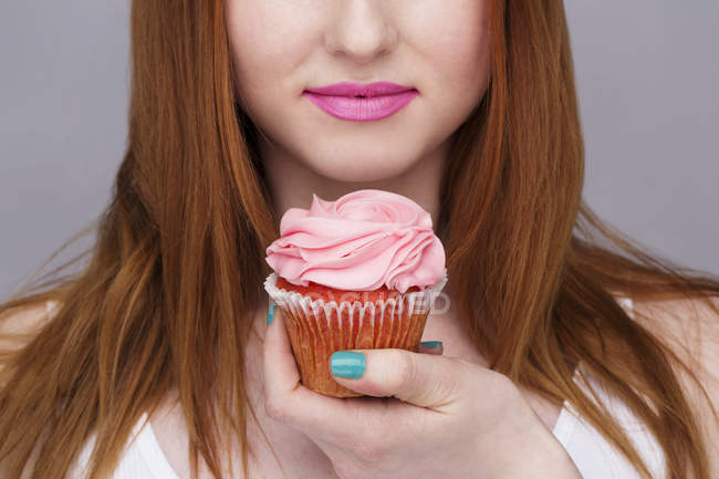 Immagine ritagliata di giovane donna in possesso di cupcake — Foto stock