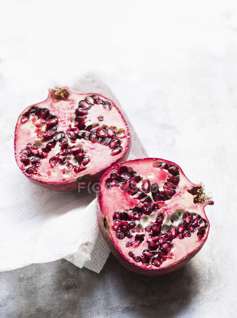 Top view of sliced pomegranate fruit with napkin — Stock Photo