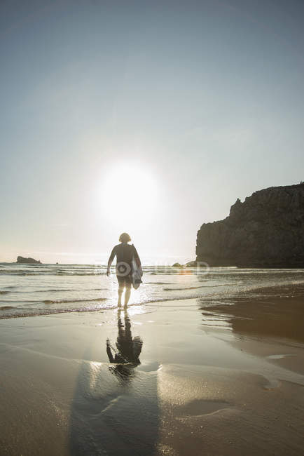 Seniorin geht mit Surfbrett in Richtung Meer, Camaret-sur-mer, Bretagne, Frankreich — Stockfoto