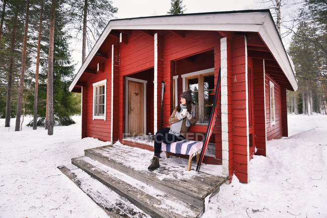 Retrato de uma jovem esquiadora bebendo café no alpendre da cabine, Posio, Lapônia, Finlândia — Fotografia de Stock