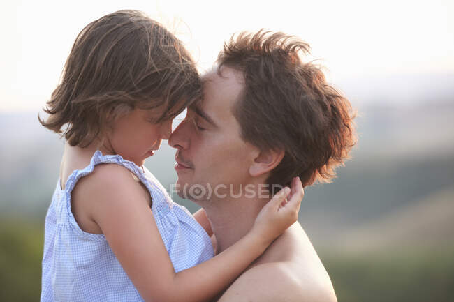 Retrato de hombre e hija cara a cara con los ojos cerrados, Buonconvento, Toscana, Italia - foto de stock