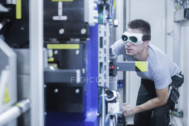 Инженер, в защитных очках, работает на машиностроительном заводе — стоковое фото