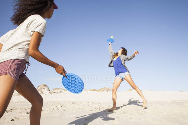 Twp молодые женщины на пляже играть в теннис — стоковое фото