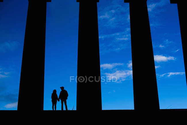 Ein junges paar hält hände am nationalen denkmal von schottland auf dem calton hill in edinburgh — Stockfoto