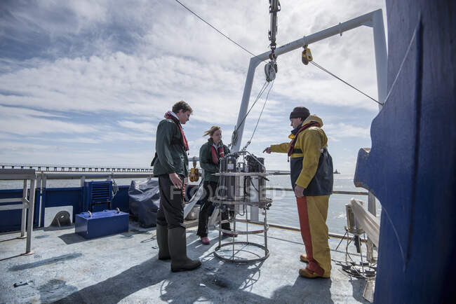 Scienziati che assemblano esperimenti di campionamento dell'acqua di mare su navi da ricerca — Foto stock