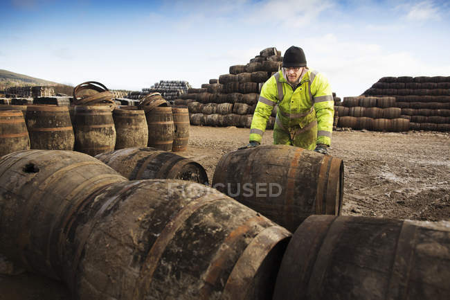 Junger Mann rollt Whisky-Fass in Küferei — Stockfoto