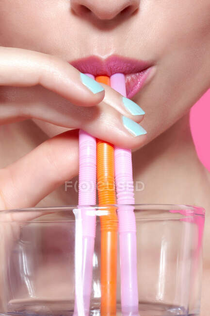 Close up of woman drinking with straws — Stock Photo