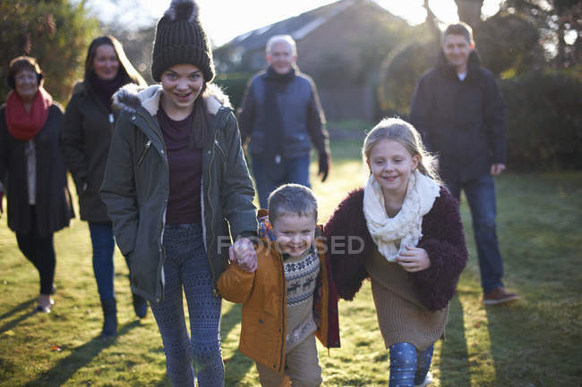 Family enjoying sun in garden together during cold weather — Stock Photo