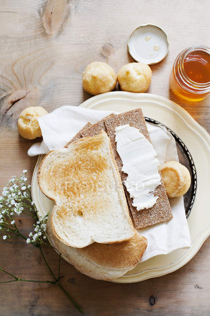 Still life with bread, puffs and honey on table — Stock Photo