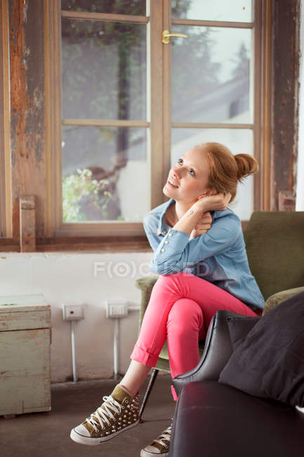 Молодая женщина сидит со скрещенными ногами — стоковое фото
