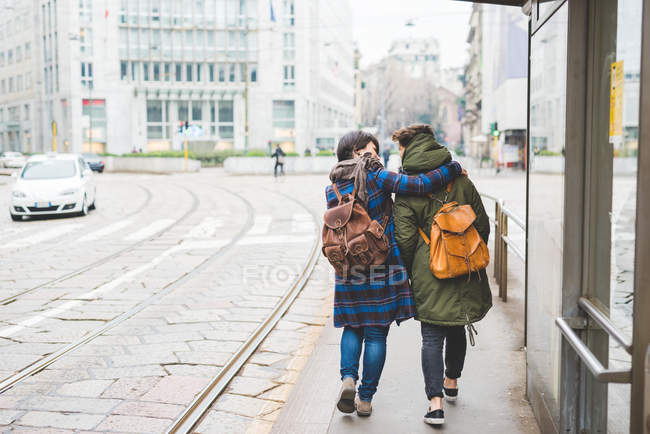 Deux sœurs marchant le long de la rue, vue arrière — Photo de stock