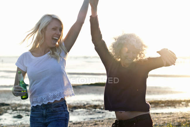 Мать и дочь танцуют на пляже Борнмут, Дорсет, Великобритания — стоковое фото