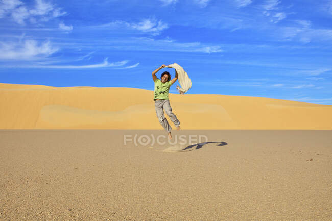 Прыжки среднего взрослого человека, Великое песчаное море, Египет, Африка — стоковое фото