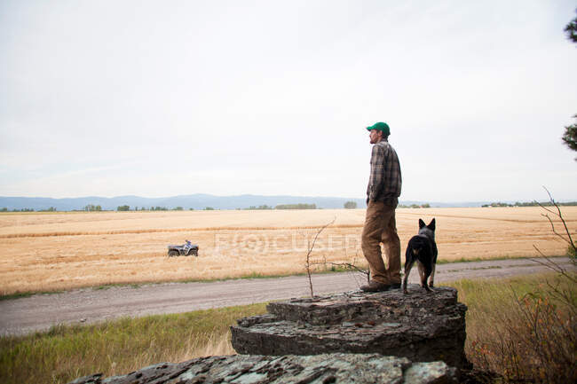 Man with dog on rock formation — Stock Photo