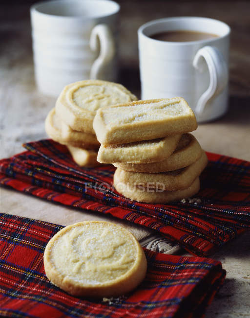 Scottish all butter shortbread biscuits stacked on tartan tea towel — Stock Photo