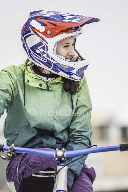 Smiling young adult female mountain biker on bike — Stock Photo