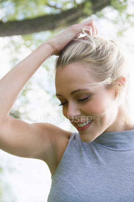 Portrait of young woman with eyes closed and hand in hair — Stock Photo