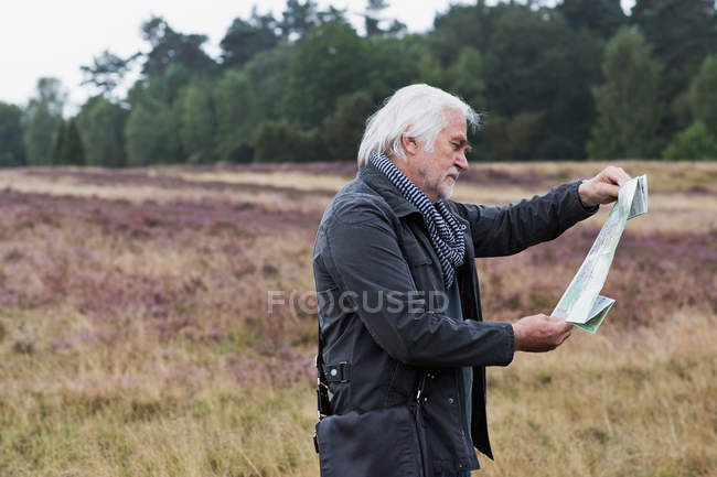 Uomo anziano che guarda la mappa — Foto stock