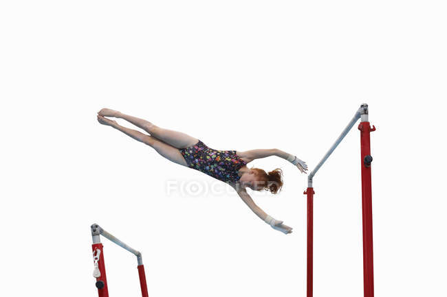 Молодая гимнастка выступает на неровных брусьях — стоковое фото