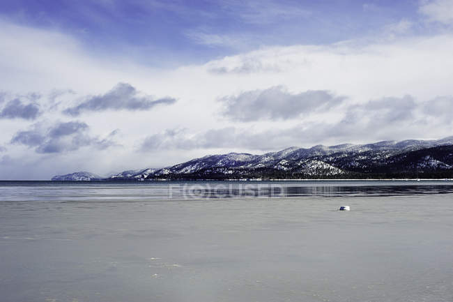Lake Tahoe and mountains under cloudy sky in winter — Stock Photo