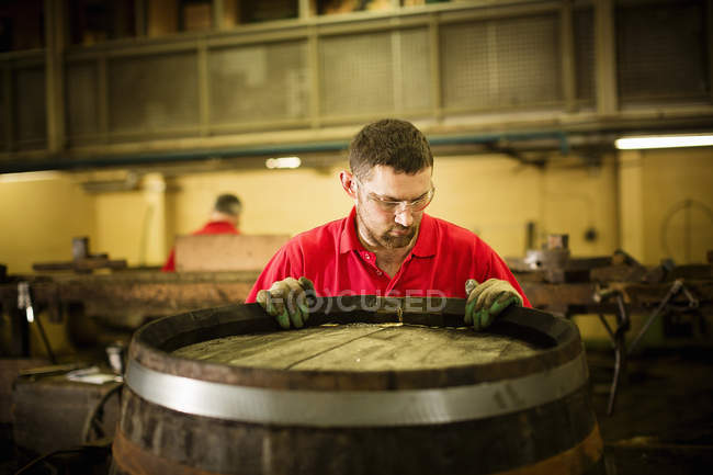 Male cooper working in cooperage with whisky cask — Stock Photo