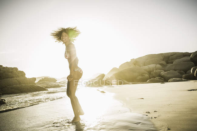 Woman swinging head on beach — Stock Photo