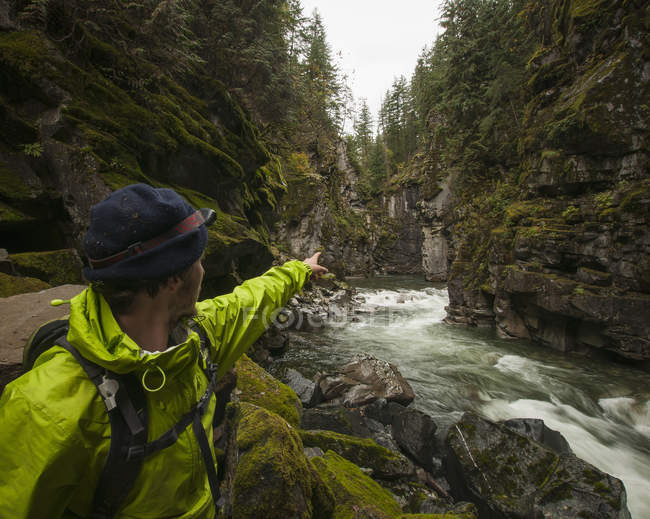 Пешеходный турист с фарой, указывающей на 300-футовые гранитные скалы, которые охватывают провинциальный парк Кокихалла-Каньон и тоннели Отелло. Часть Транс-канадского пути, Хоуп, Британская Колумбия, Канада — стоковое фото