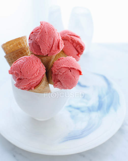 Bowl of strawberry ice cream cones on plate — Stock Photo