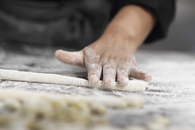 Frau arbeitet in Restaurantküche, zugeschnittene Teigtaschen — Stockfoto