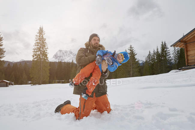Vater hebt Sohn in Schnee, Elmau, Bayern, Deutschland — Stockfoto