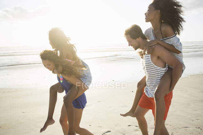 Giovane uomo e donna tra amici in gara sulla spiaggia, Città del Capo, Sud Africa — Foto stock