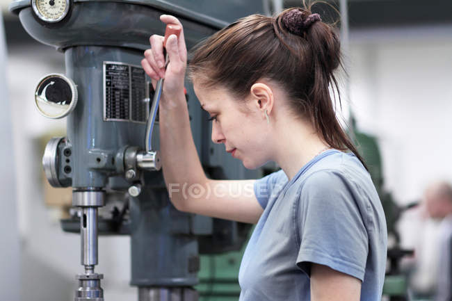 Female engineer using machine in workshop — Stock Photo