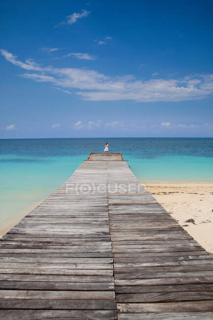 Donna sul molo di legno sulla spiaggia tropicale — Foto stock