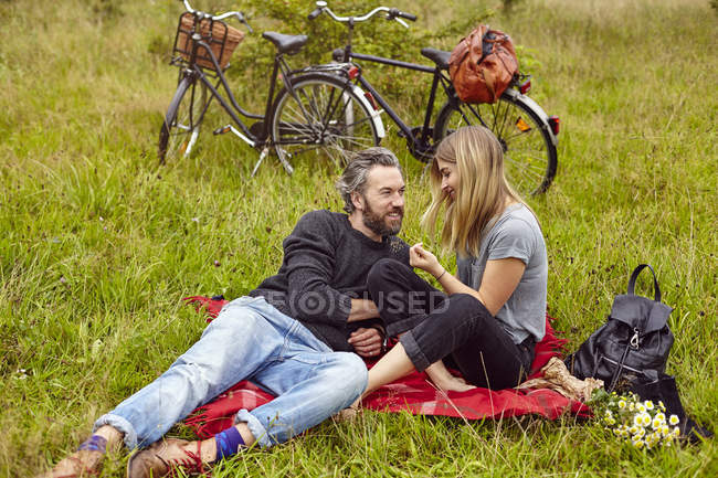 Casal romântico sentado em piquenique no campo rural — Fotografia de Stock